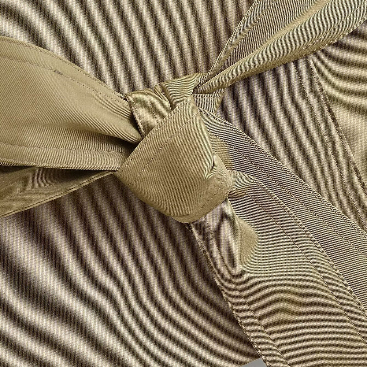 Close-up of the tie belt knot on the khaki trench waistcoat
