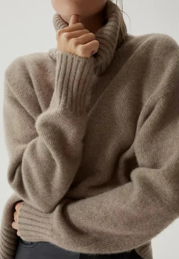 Close-up of the taupe Mabel turtleneck showing the deep folded neck and ribbed cuffs