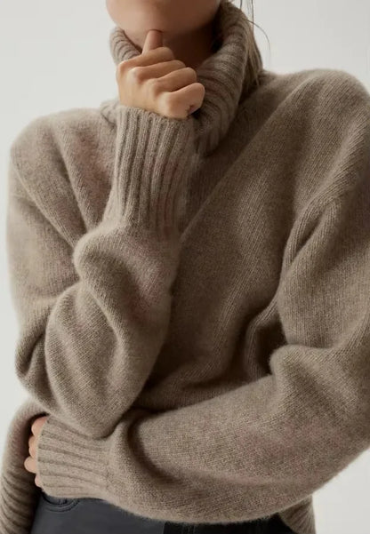 Close-up of the taupe Mabel turtleneck showing the deep folded neck and ribbed cuffs