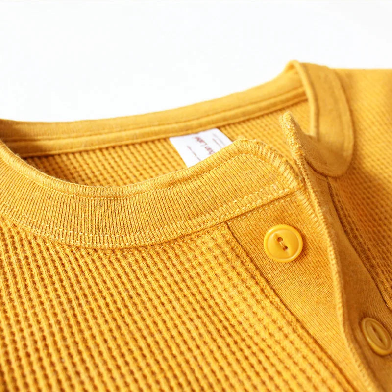 Detail of the waffle-knit texture and ribbed neckline on the Harlow henley