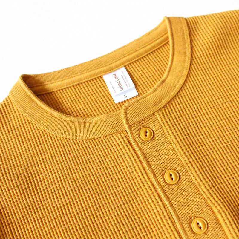 Close-up of the Harlow henley's ribbed collar and buttons in mustard