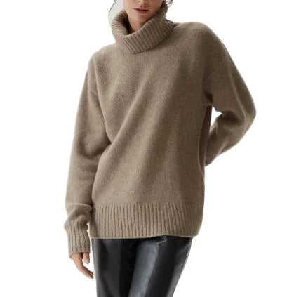 Woman wearing the Mabel Oversized Turtleneck Jumper in taupe with black leather trousers